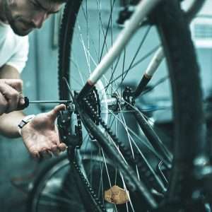Cyclist adjusting bicycle derailleur for smooth gear shifting