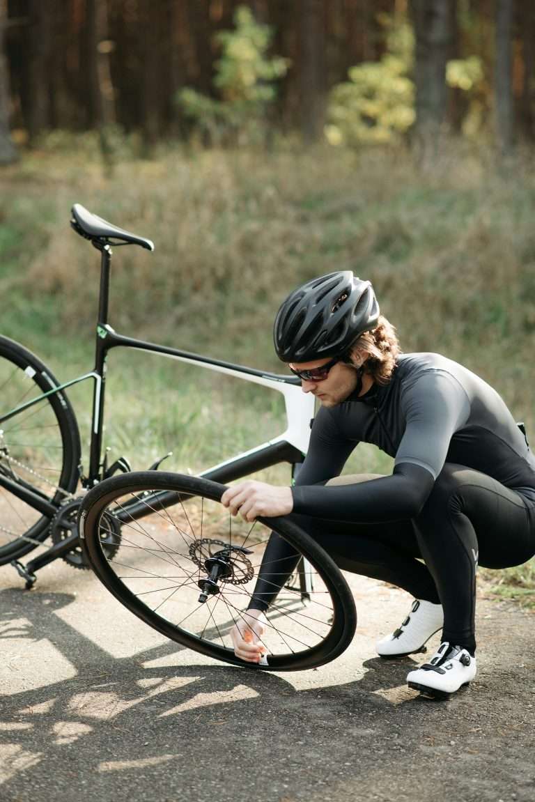 Cyclist fixing a flat bicycle tire on the roadside